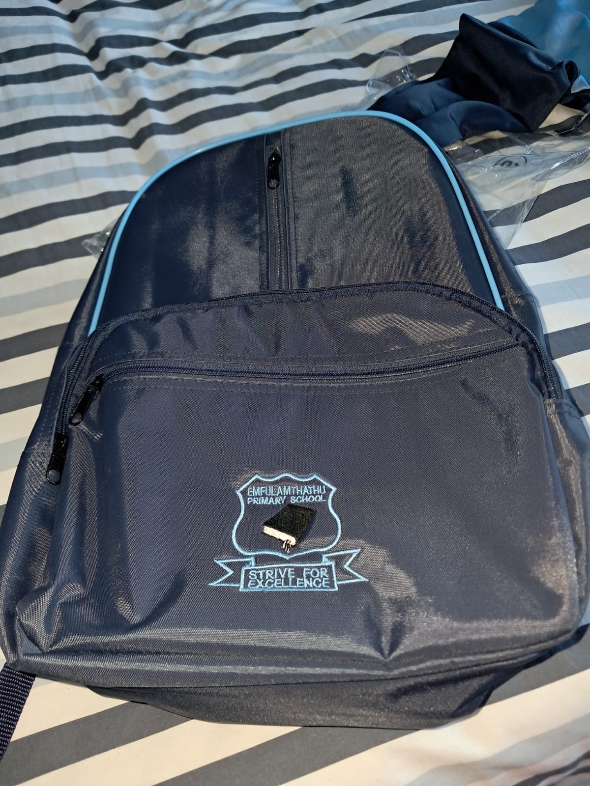 Navy backpack with Emfulamthathu Primary School embroidery